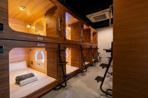 a room with a row of bunk beds in it at Jpod Capsule Hotel in Kota Kinabalu