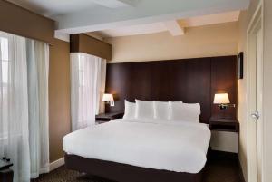 a large white bed in a hotel room at Best Western Syracuse Downtown Hotel and Suites in Syracuse