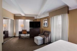 Habitación de hotel con cama, escritorio y TV. en Best Western Syracuse Downtown Hotel and Suites en Syracuse