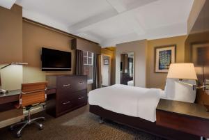 a hotel room with a bed and a desk and a computer at Best Western Syracuse Downtown Hotel and Suites in Syracuse