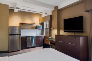 a hotel room with a bed and a television at Best Western Syracuse Downtown Hotel and Suites in Syracuse