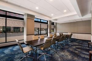 Best Western Syracuse Downtown Hotel and Suites في سيراكيوز: قاعة المؤتمرات مع طاولة وكراسي طويلة