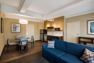 a living room with a blue couch and a table at Best Western Syracuse Downtown Hotel and Suites in Syracuse