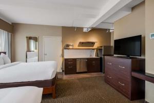 a hotel room with a bed and a flat screen tv at Best Western Syracuse Downtown Hotel and Suites in Syracuse