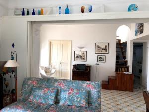 a living room with a couch and a room with a staircase at Borgo Antico di Capri in Capri
