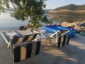 un tavolo e due zattere sulla riva di un lago di Beach apartments Seahorse and Seastar, Pelješac peninsula a Putniković