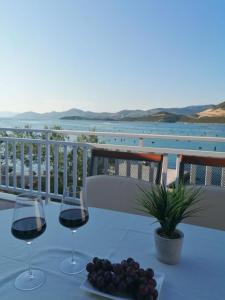un tavolo con due bicchieri di vino e un piatto di uva di Beach apartments Seahorse and Seastar, Pelješac peninsula a Putniković