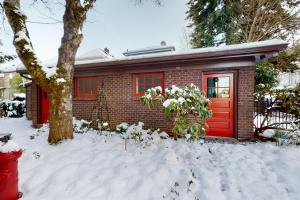 a red house with a red door in the snow at Firehouse 17 in Portland