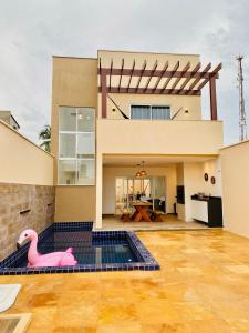 a house with a swimming pool with a pink flamingo at Casa Flecheiras 52 in Flecheiras