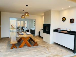 a kitchen and dining room with a wooden table at Casa Flecheiras 52 in Flecheiras