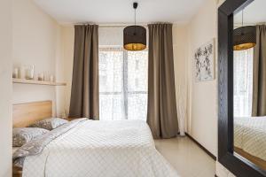 um quarto com 2 camas e uma grande janela em Apartament Wiktoria Wilanów em Varsóvia