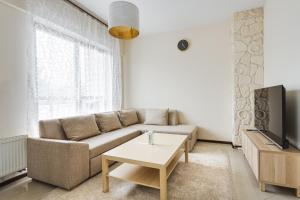uma sala de estar com um sofá e uma mesa de centro em Apartament Wiktoria Wilanów em Varsóvia