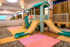 a playground with a slide in a room at Puffer Isle Resort in Dingalan