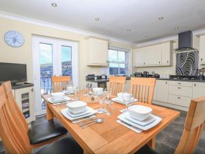 eine Küche mit einem Holztisch mit Tellern und Weingläsern in der Unterkunft 29 Above Town in Dartmouth