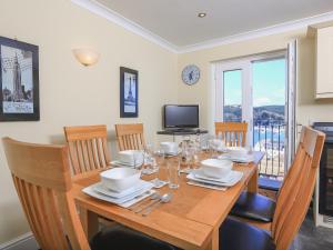 ein Esszimmer mit einem Holztisch und Stühlen in der Unterkunft 29 Above Town in Dartmouth