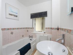 ein Badezimmer mit einer weißen Badewanne und einem Waschbecken in der Unterkunft 29 Above Town in Dartmouth + 23 Fotos