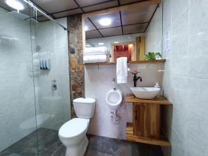 y baño con aseo, lavabo y ducha. en CABAÑAS MONTEVERDE - Guarne ANT, en Guarne