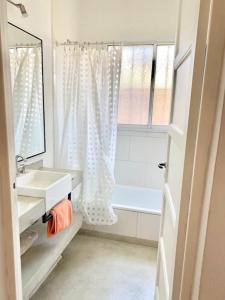 ein Badezimmer mit Waschbecken, Spiegel und Badewanne in der Unterkunft Hermosa casa céntrica in San Antonio de Areco