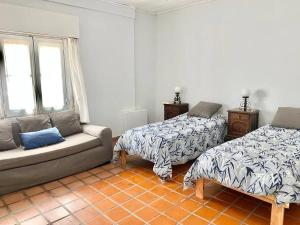 sala de estar con 2 camas y sofá en Hermosa casa céntrica, menos en euro usd en San Antonio de Areco