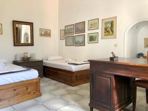 a room with two beds and a vanity and a mirror at Traditional House at Aegina Port in Egina
