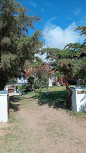 un patio con una puerta, árboles y césped en Familia del Viento en Ostende