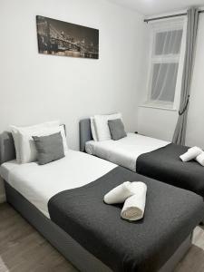 duas camas sentadas uma ao lado da outra num quarto em Seven Suites - Beautiful 2-Bed Apartment with Parking in Watford Central em Watford