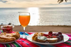 una mesa con un plato de comida y un vaso de cerveza en cabañas samawi, en Copacabana