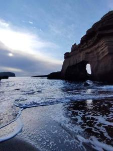 a beach with a rock formation in the water at Hotel Villa Iulia in Ventotene