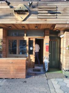 Backstage Party Hostel & Bar في أوساكا: رجل واقف عند مدخل المطعم