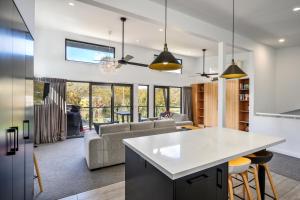 een keuken en een woonkamer met een tafel en stoelen bij Monument Chalet in Crakenback Resort in Crackenback