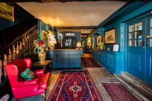 a living room with blue walls and a red chair at The George Inn in Oakham