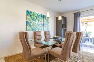 a dining room with a glass table and chairs at Ojanea Home in Palm-Eagle Beach