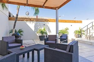 a patio with wicker chairs and tables on a patio at Ojanea Home in Palm-Eagle Beach