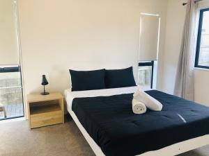 1 dormitorio con 1 cama grande con manta azul en Cozy Brand New Townhouse 24, en Auckland