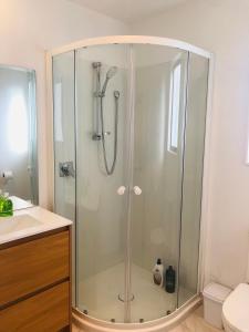 y baño con ducha y puerta de cristal. en Cozy Brand New Townhouse 24, en Auckland