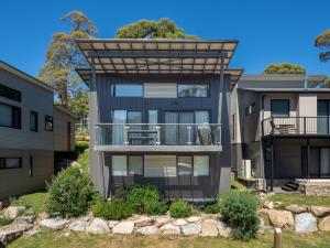 an exterior view of a house with a balcony at Monument Chalet in Crakenback Resort in Crackenback