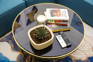 a table with a potted plant and a remote control at Nazari Apartment 1 in Tirana