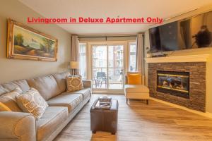 a living room with a couch and a fireplace at Windtower Lodge - Canmore in Canmore