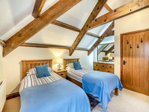 2 bedden in een kamer met houten plafonds bij Puffin Cottage - Uk42131 in Bamburgh