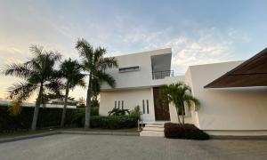 a white house with palm trees in front of it at Casa en Anapoima Estilo Mediterráneo in Anapoima