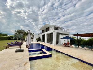 a villa with a swimming pool and a house at Casa en Anapoima Estilo Mediterráneo in Anapoima
