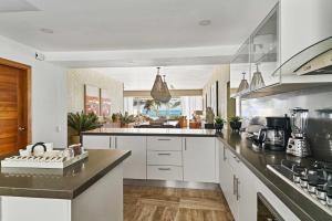 a kitchen with white cabinets and black counter tops at Costa Atlantica Punta Cana - Beach Vacation Condos in Punta Cana