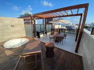 a balcony with a table and chairs on a roof at Bela Hospedagem - EcoSummer Cobertura em Tambaú in João Pessoa