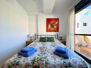 sypialnia z dużym łóżkiem i niebieskimi poduszkami w obiekcie Apartment near beach with pools in Spain w mieście Los Amarguillos +32 zdjęcia