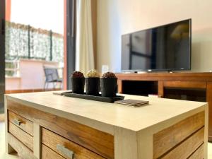 a coffee table with three cups on top of it at Apartment near beach with pools and hot tub in Los Amarguillos