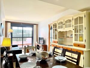 a kitchen and dining room with a table and chairs at Apartment near beach with pools and hot tub in Los Amarguillos