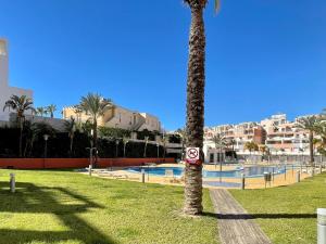 Los Amarguillos的住宿－Lavish apartment in Vera Playa with hot tub，游泳池旁公园里的棕榈树