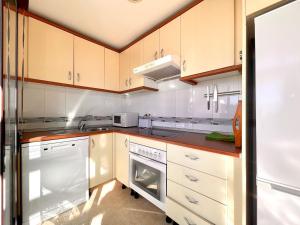 eine Küche mit weißen Geräten und Holzschränken in der Unterkunft Premium apartment in Carboneras with relaxation area in Carboneras