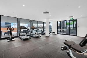 a gym with several tread machines in a building at Kooii Apartments in Brisbane