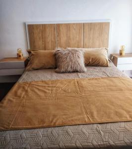 a bedroom with a large bed with a wooden headboard at Bienestar Haedo in Mariano J. Haedo